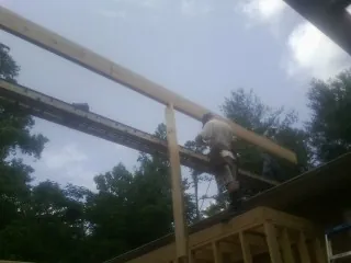 Carpenter setting a ridge beam over a new addition frame — Ice Dam Removal by Roofing Brothers in Woodsfield