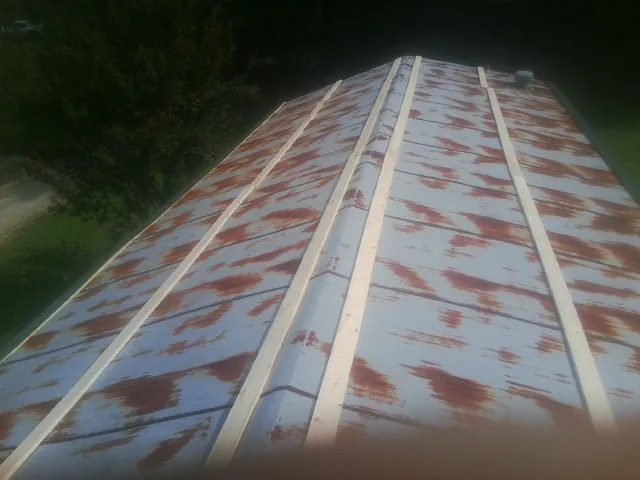 Rusted metal roof panels with new wood purlins before replacement — Storm Damage Roof Repair in Woodsfield by Roofing Brothers