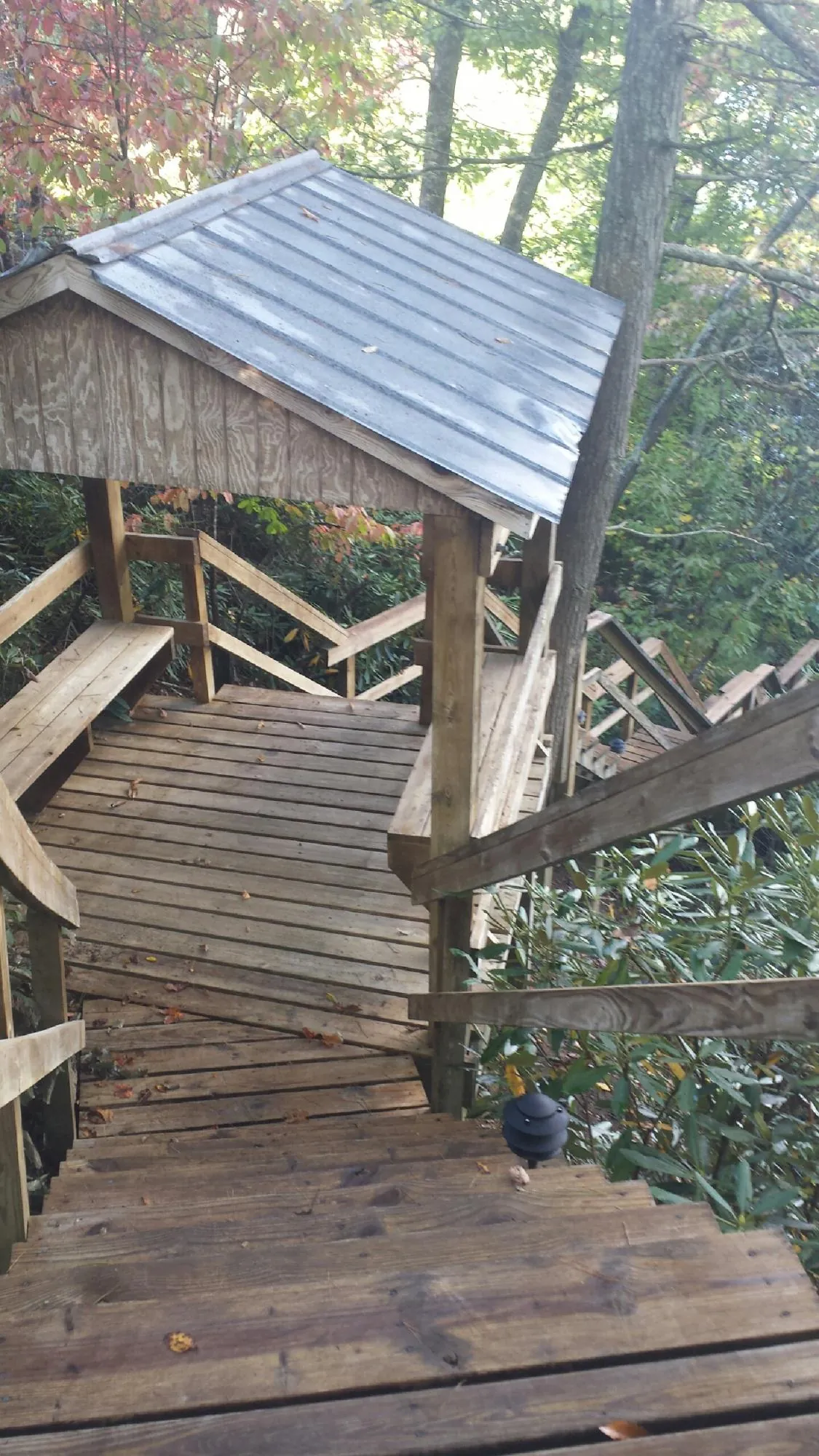 Metal roofed shelter over wooden steps on a wooded walkway — Skylight Repair & Installation work by our crew in Woodsfield