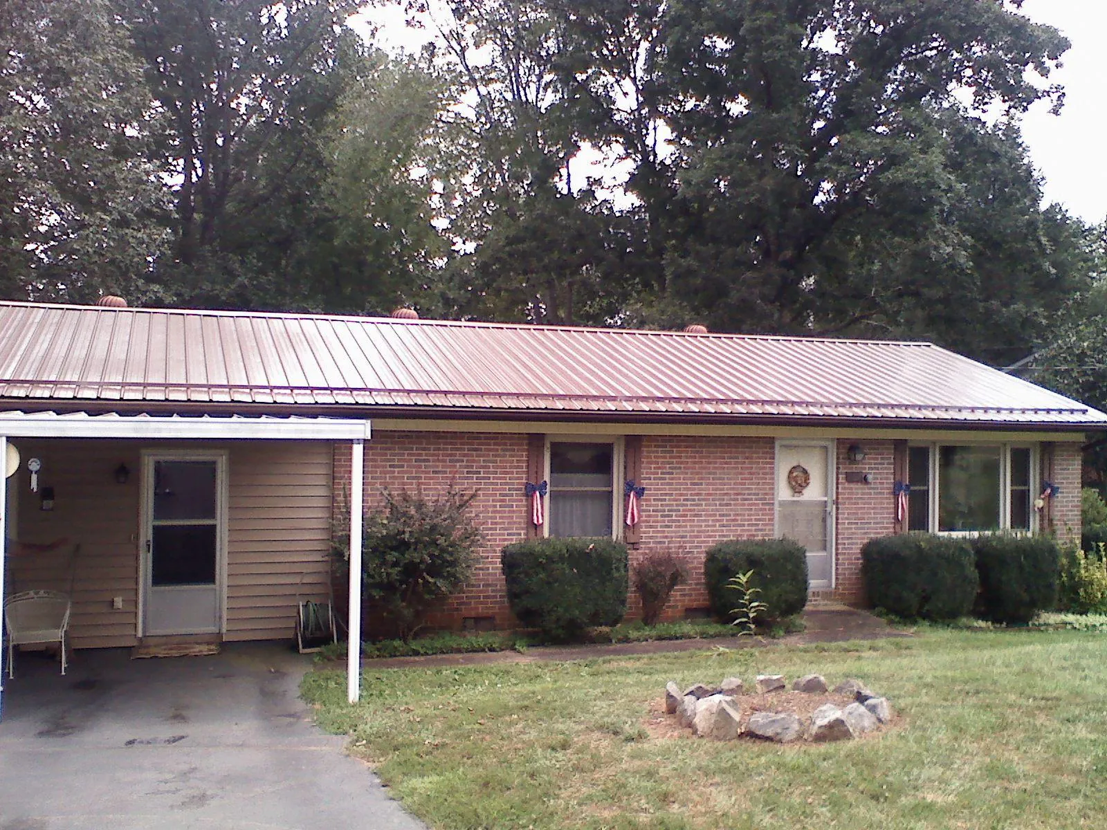 Bronze metal roof and carport on a brick ranch home — Roof Repair work by our crew in Woodsfield